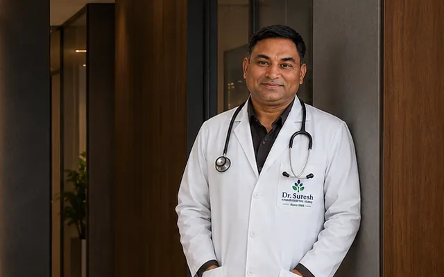 Rohit in a white doctor's coat with a stethoscope, standing in a clinic corridor